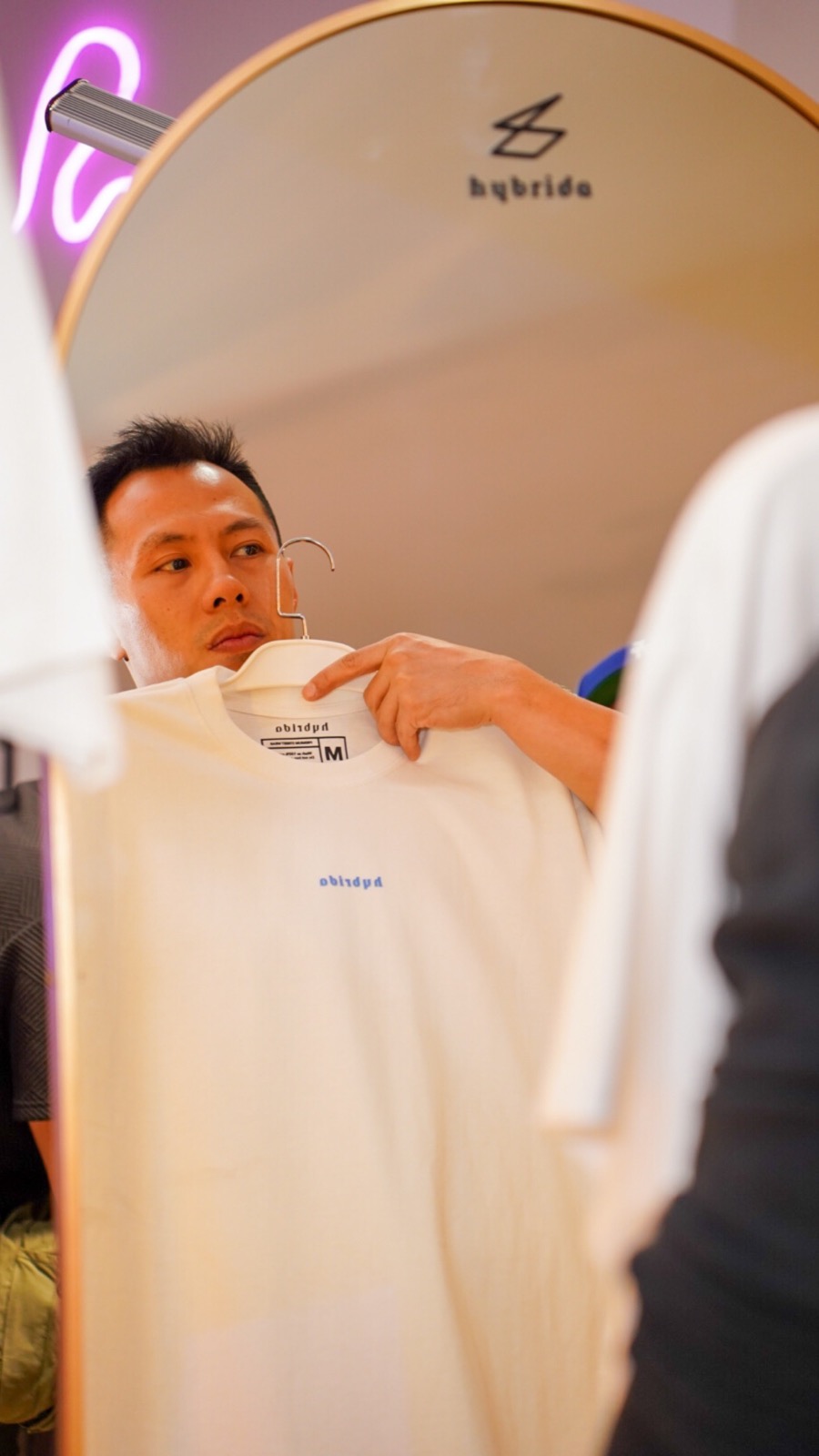Hybrida QuieroCon popup customer holding a white tee