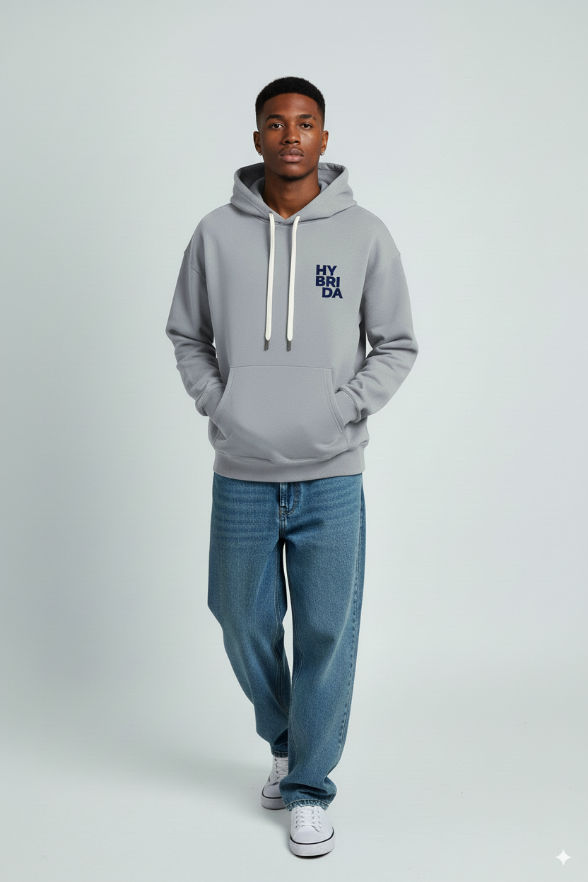 Person wearing a gray hoodie with text and blue jeans on a white background